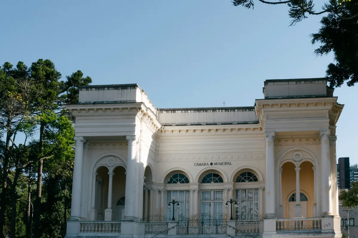 Fachada de prédio público antigo, branco, com colunas e janelas em arco